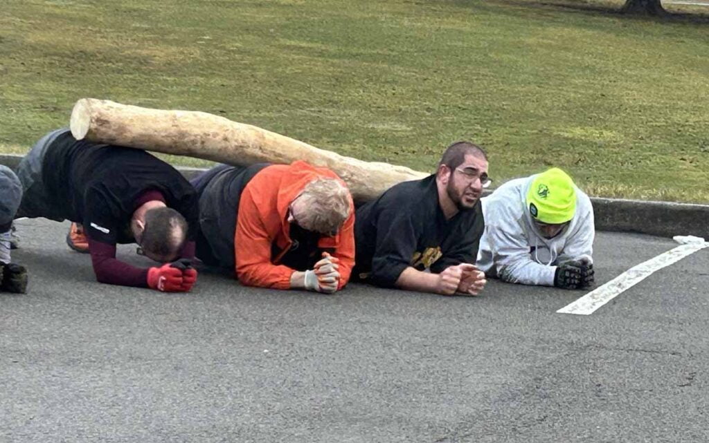 men working out with a log on their backs in Lehigh Valley, PA.